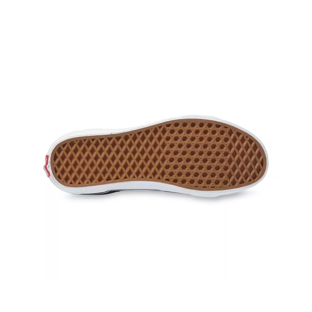 Close-up of a shoe sole with a brown waffle pattern on a white background
