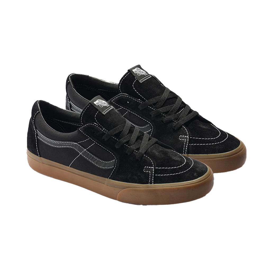 Pair of black sneakers with brown soles on a white background