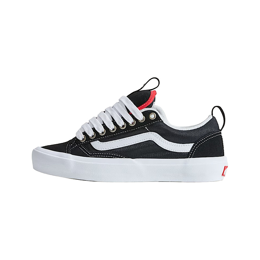 Black and white sneaker with red accents on a white background