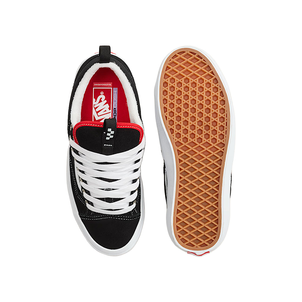 Black and white sneaker with red interior and brown sole on a white background