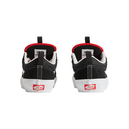 Black and white sneakers with red accents on a white background