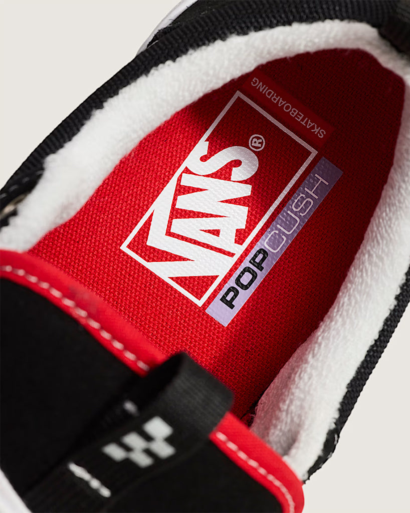 Close-up of a Vans shoe with red lining and white sole.
