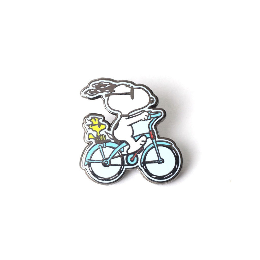 Enamel pin of Snoopy and Woodstock riding a bicycle on a white background