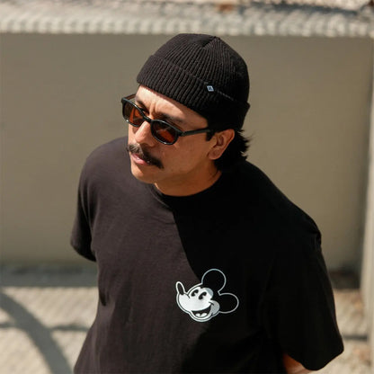 Man wearing a black beanie and sunglasses, with a black t-shirt featuring a white graphic design.
