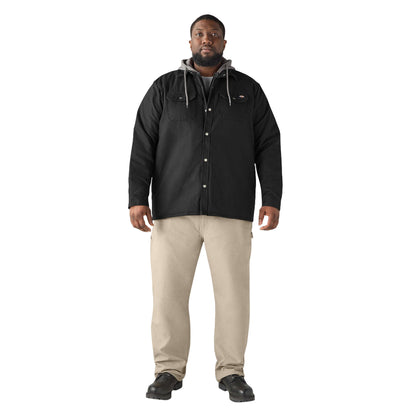 Man wearing a black jacket and beige pants on a white background