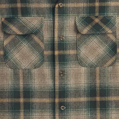 Close-up of a green and brown plaid shirt with button details.