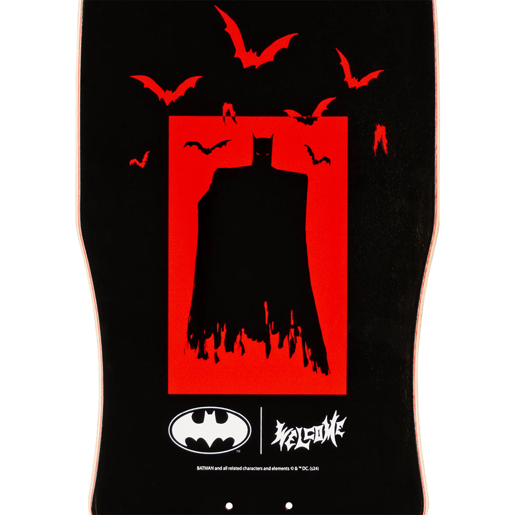 Skateboard deck with Batman silhouette and Welcome logo on a black background