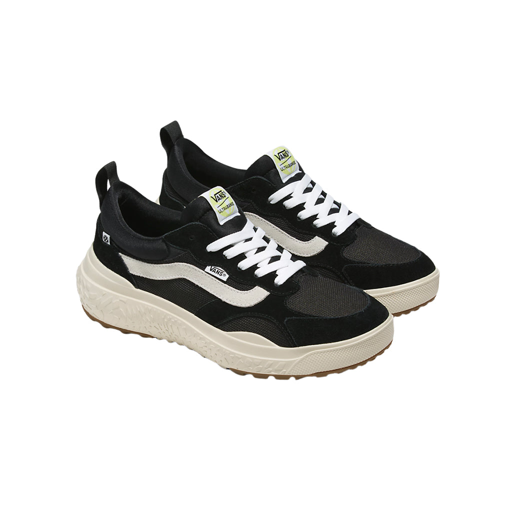 Black and white sneakers with a visible brand logo on a white background