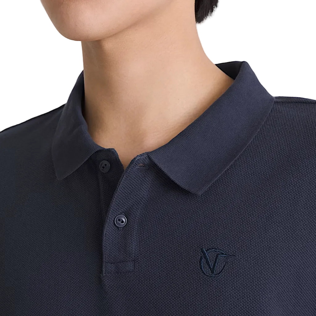 Model wearing a navy polo on a white background
