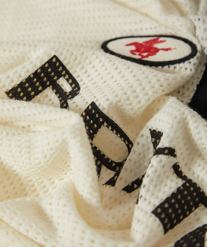 Close-up of a textured fabric with embroidered text and logo