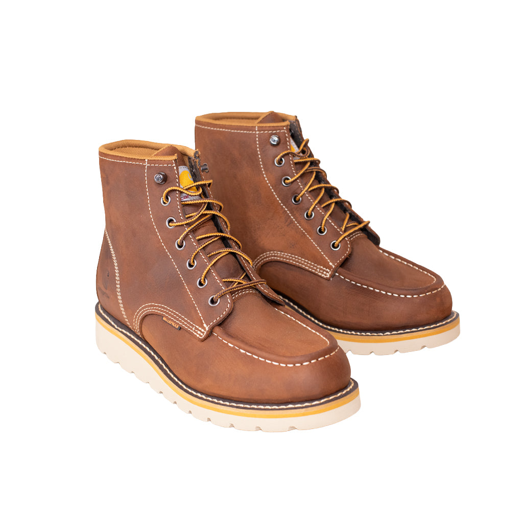 Pair of brown leather boots with white soles on a white background