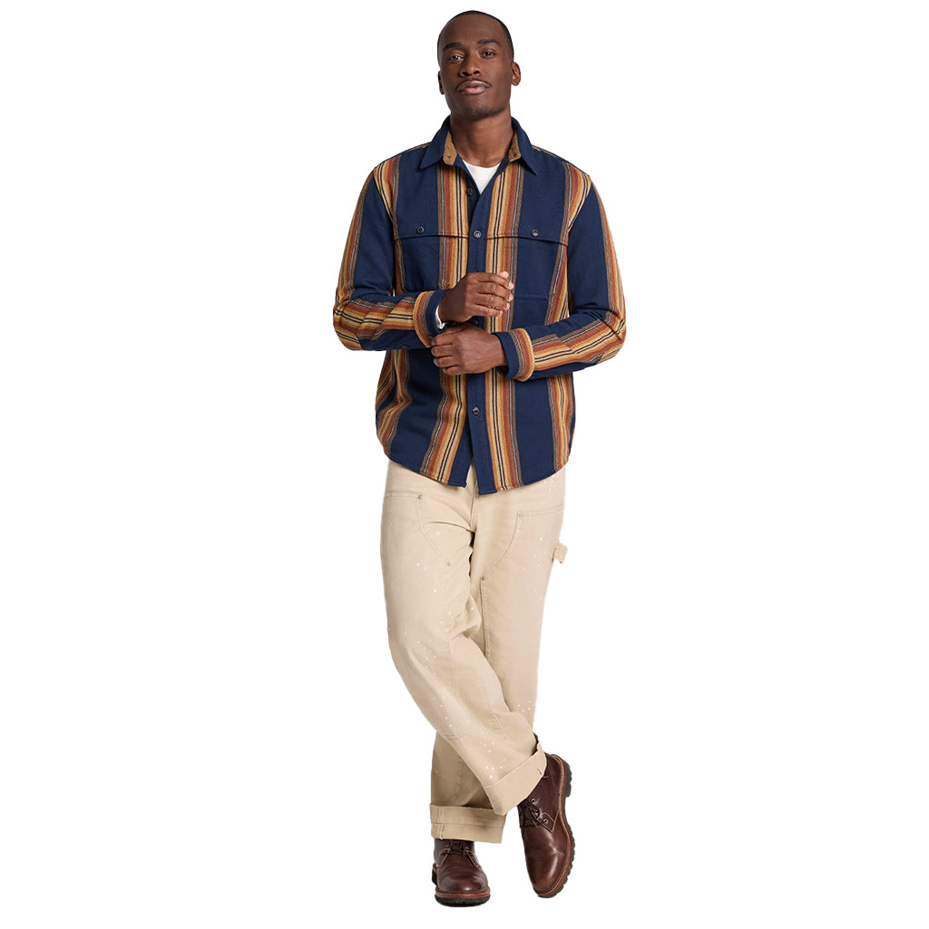 Man wearing a striped shirt and beige pants on a white background