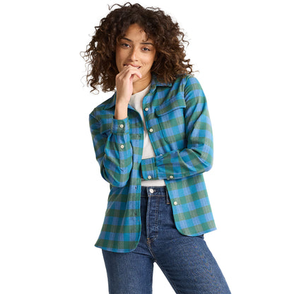 Person wearing a blue and green plaid shirt on a white background