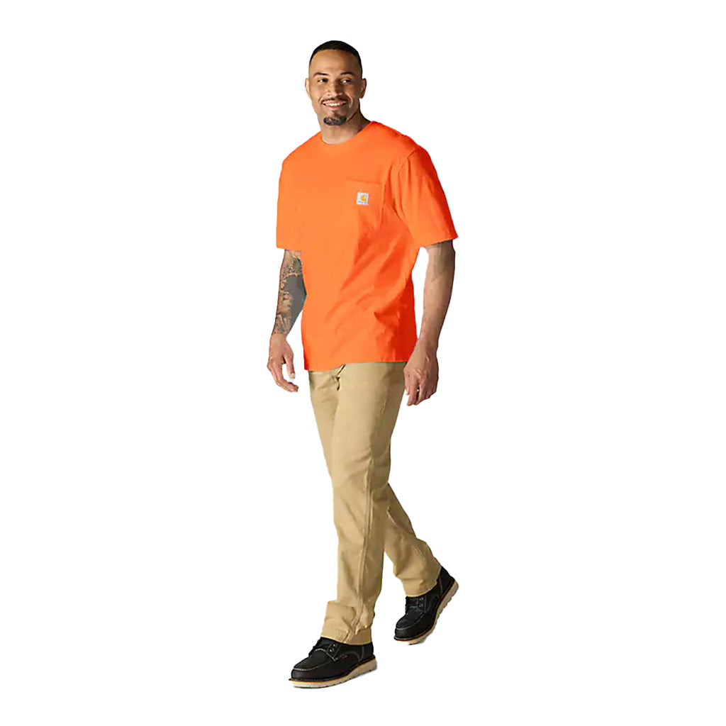 Man wearing an orange t-shirt and beige pants on a white background