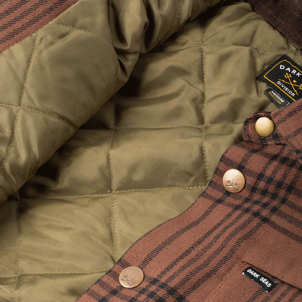 Close-up of a green quilted jacket with plaid lining and visible brand label.