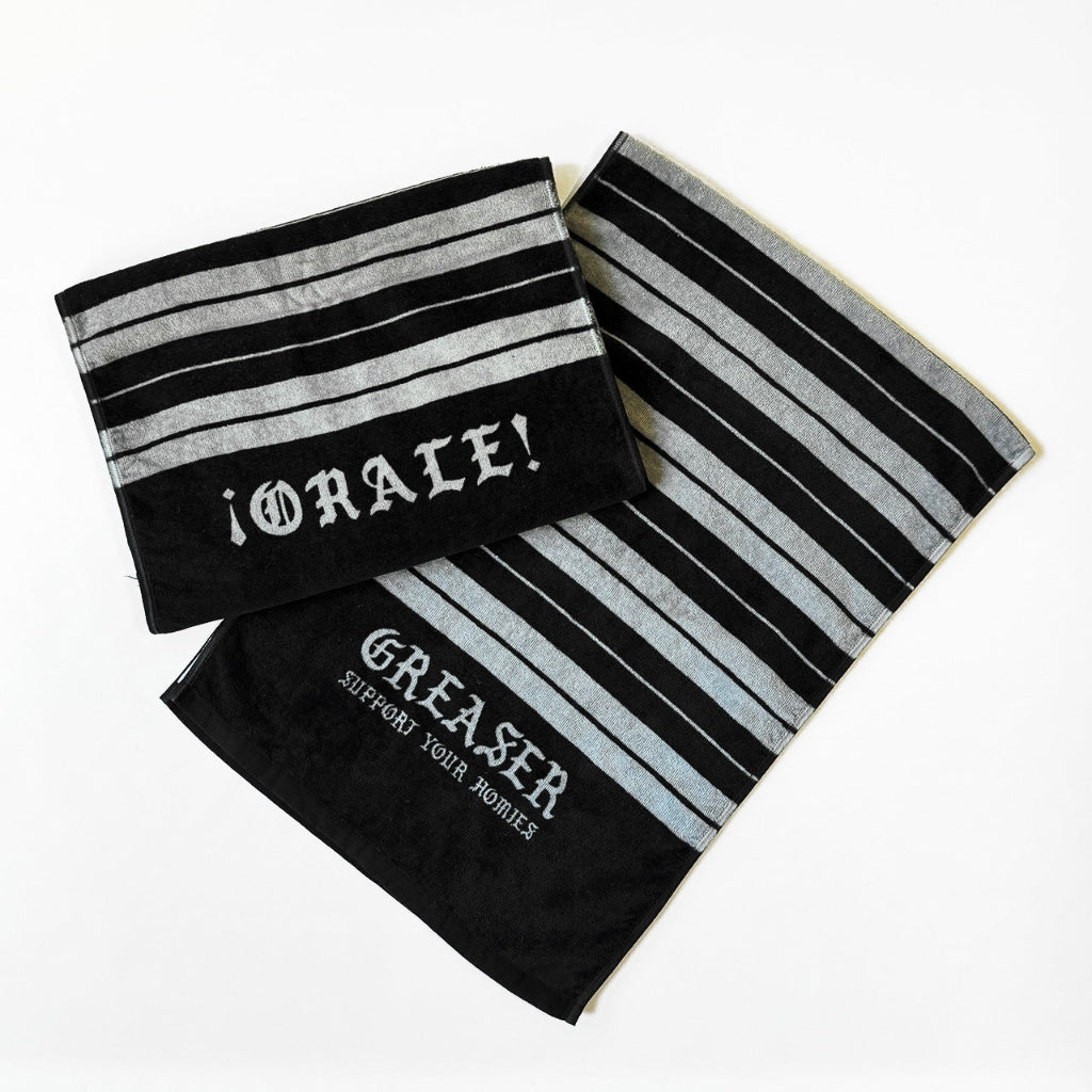 Two black and gray striped towels with 'Greaser' text on a white background