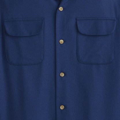 Close-up of a blue shirt with button details on a plain background