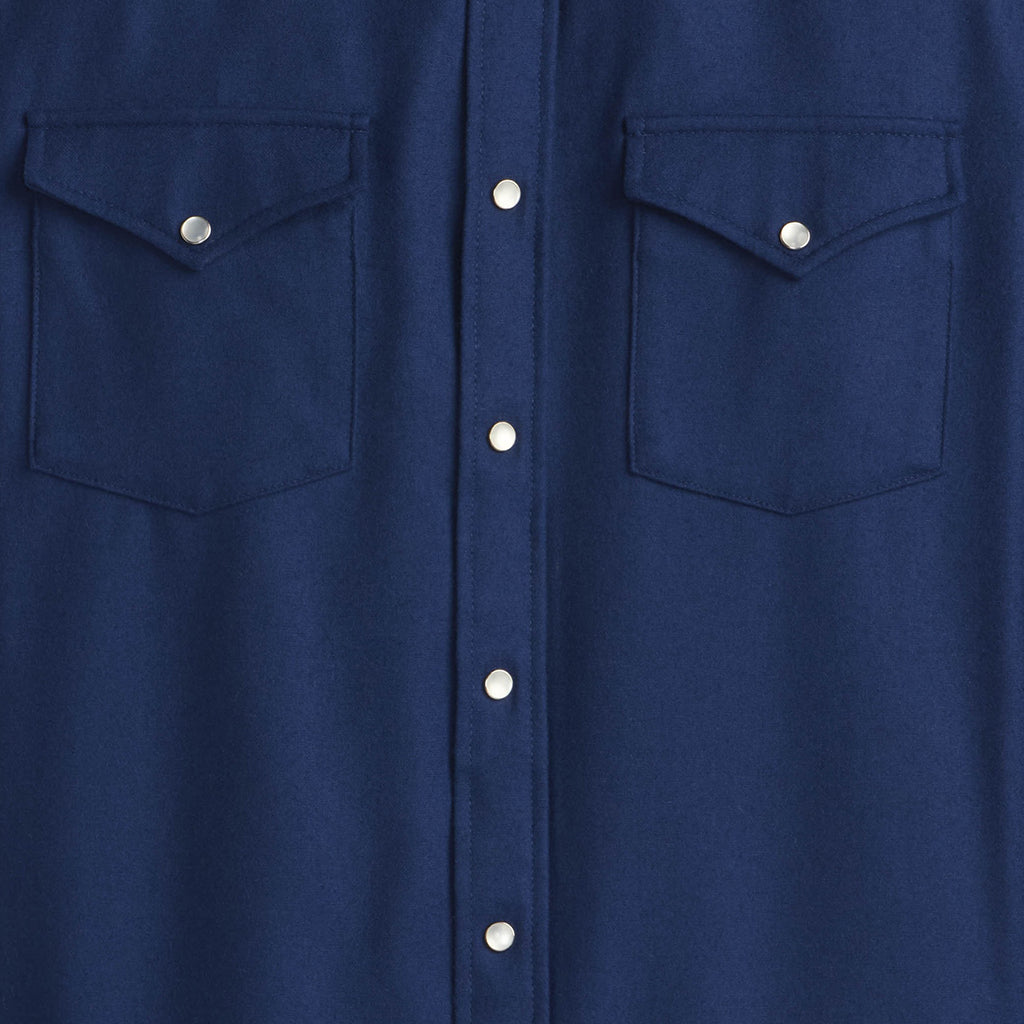 Close-up of a blue shirt with two front pockets and buttons.
