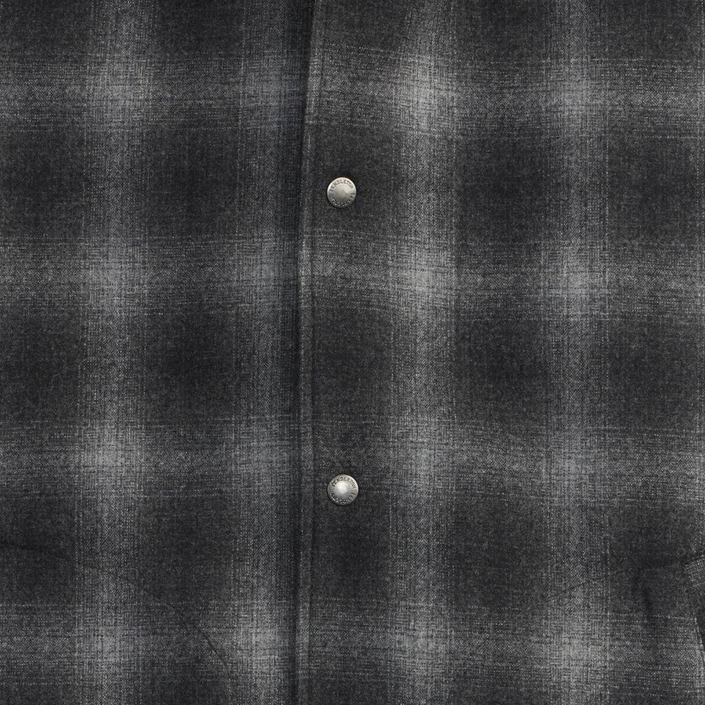 Close-up of a dark gray flannel shirt with two buttons.