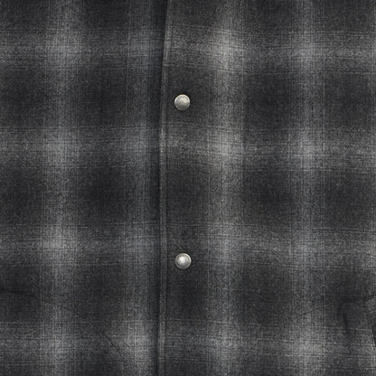 Close-up of a dark gray flannel shirt with two buttons.
