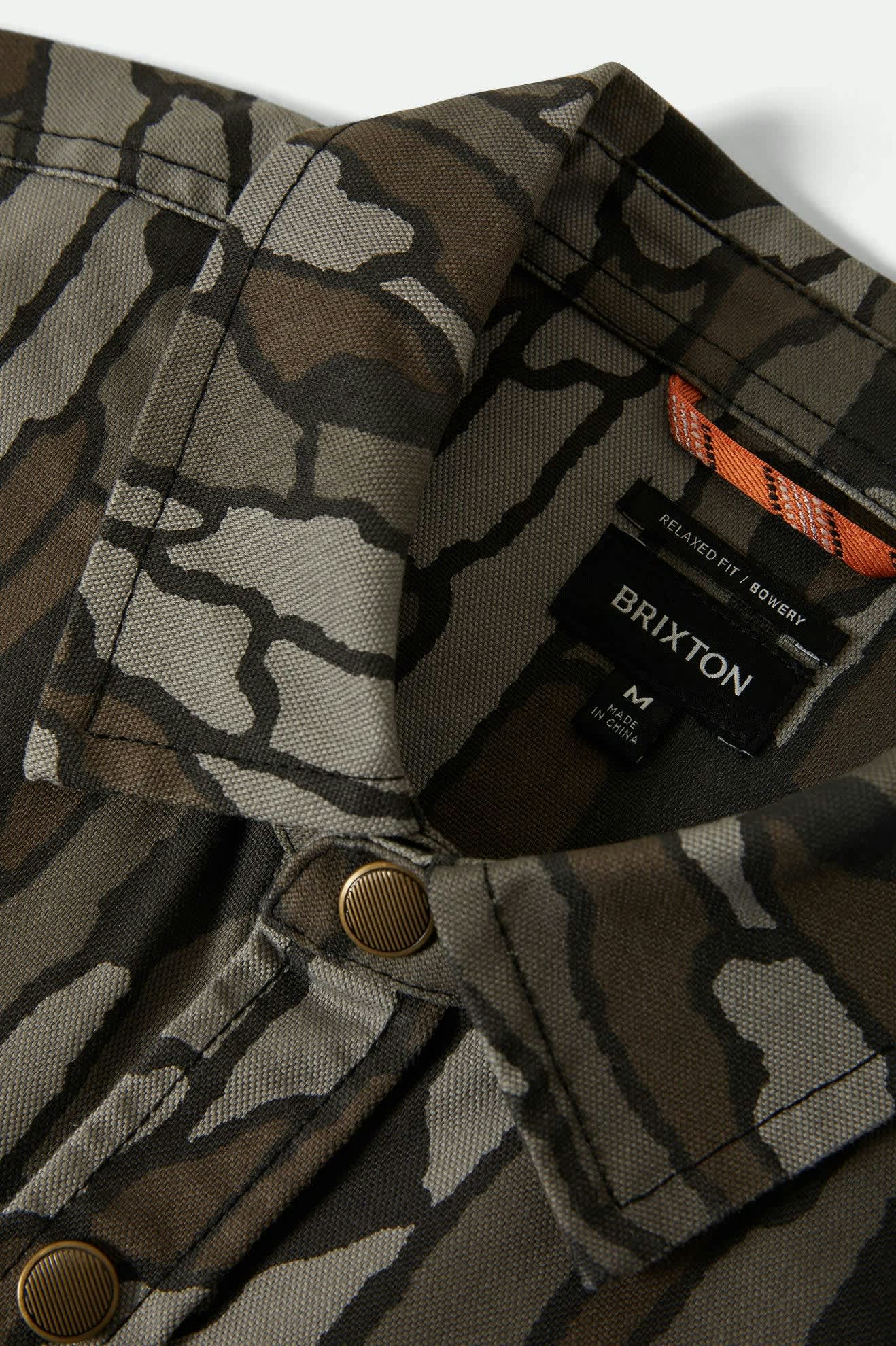 Camouflage jacket with Brixton logo and branding on a white background