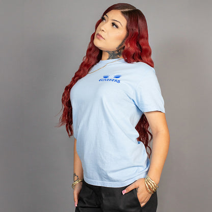 Woman wearing a light blue t-shirt with a logo on a gray background