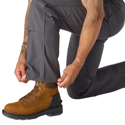 Person wearing brown leather boots with black soles on a white background
