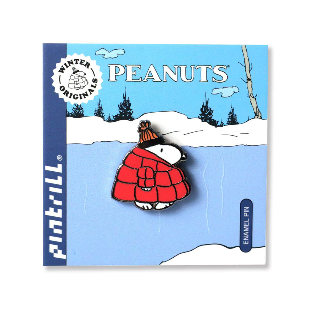 Peanuts enamel pin with Snoopy in a red coat on a blue card with a winter scene.