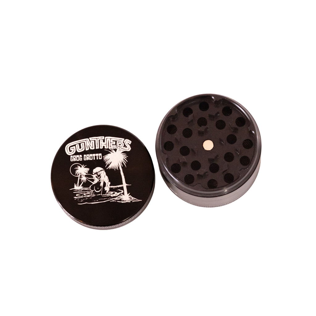 Black herb grinder with a logo on the lid against a white background