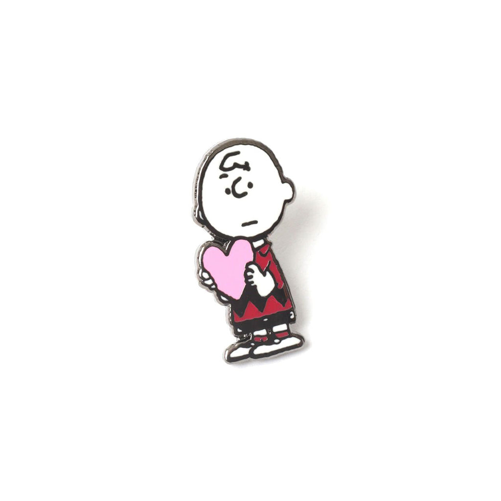 Pin of Charlie Brown holding a pink heart on a white background