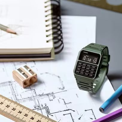 olive green casio calculator watch on a cluttered desk