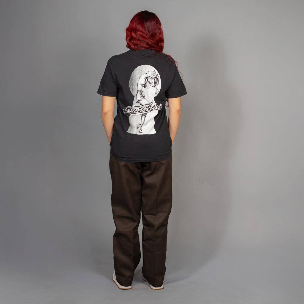 Person wearing a black t-shirt with a graphic design on the back against a gray background