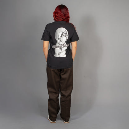 Person wearing a black t-shirt with a graphic design on the back against a gray background