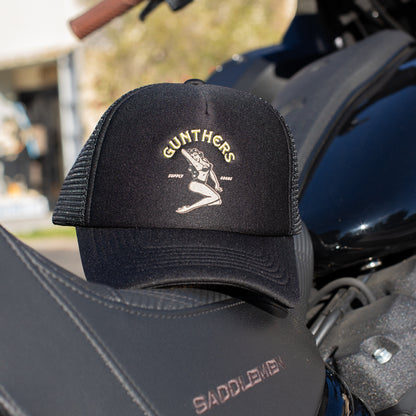 Black cap with 'Gumthers' logo on a motorcycle seat