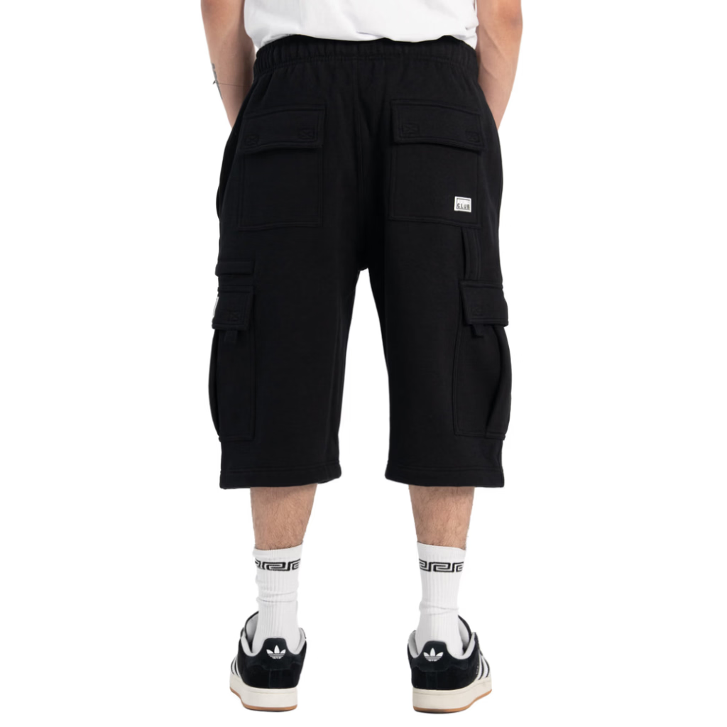 Black cargo shorts with an elastic waistband, shown from the back on a model wearing white crew socks and black and white sneakers against a white background.