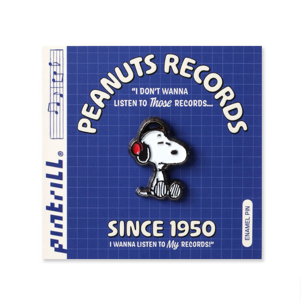 Peanuts-themed enamel pin featuring snoopy wearing headphones on a blue and white card with text