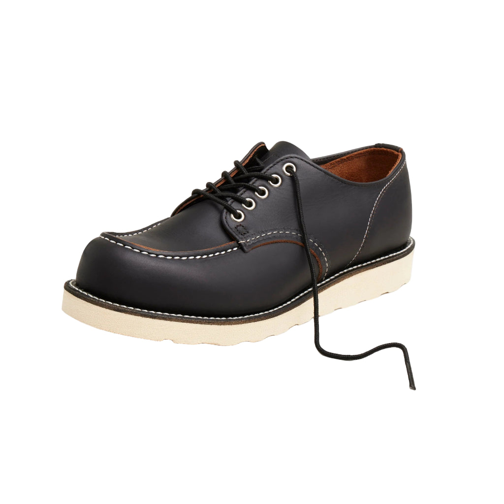 Black leather shoe with white sole on a white background