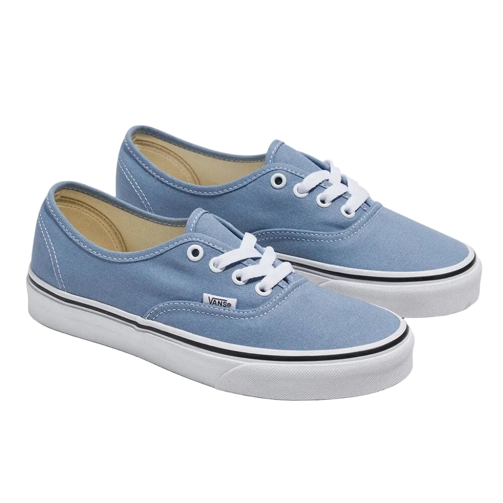 Pair of blue sneakers with white laces on a white background