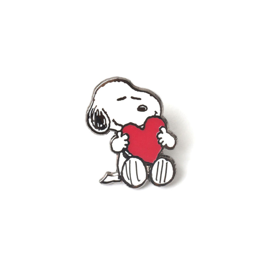 Snoopy pin holding a red heart on a white background