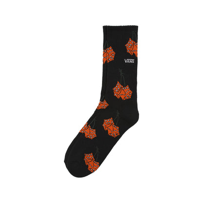 A black crew sock with orange leaf patterns and the Vans brand logo.